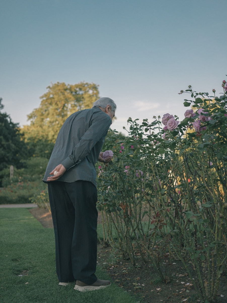 A man standing in the grass next to a bush