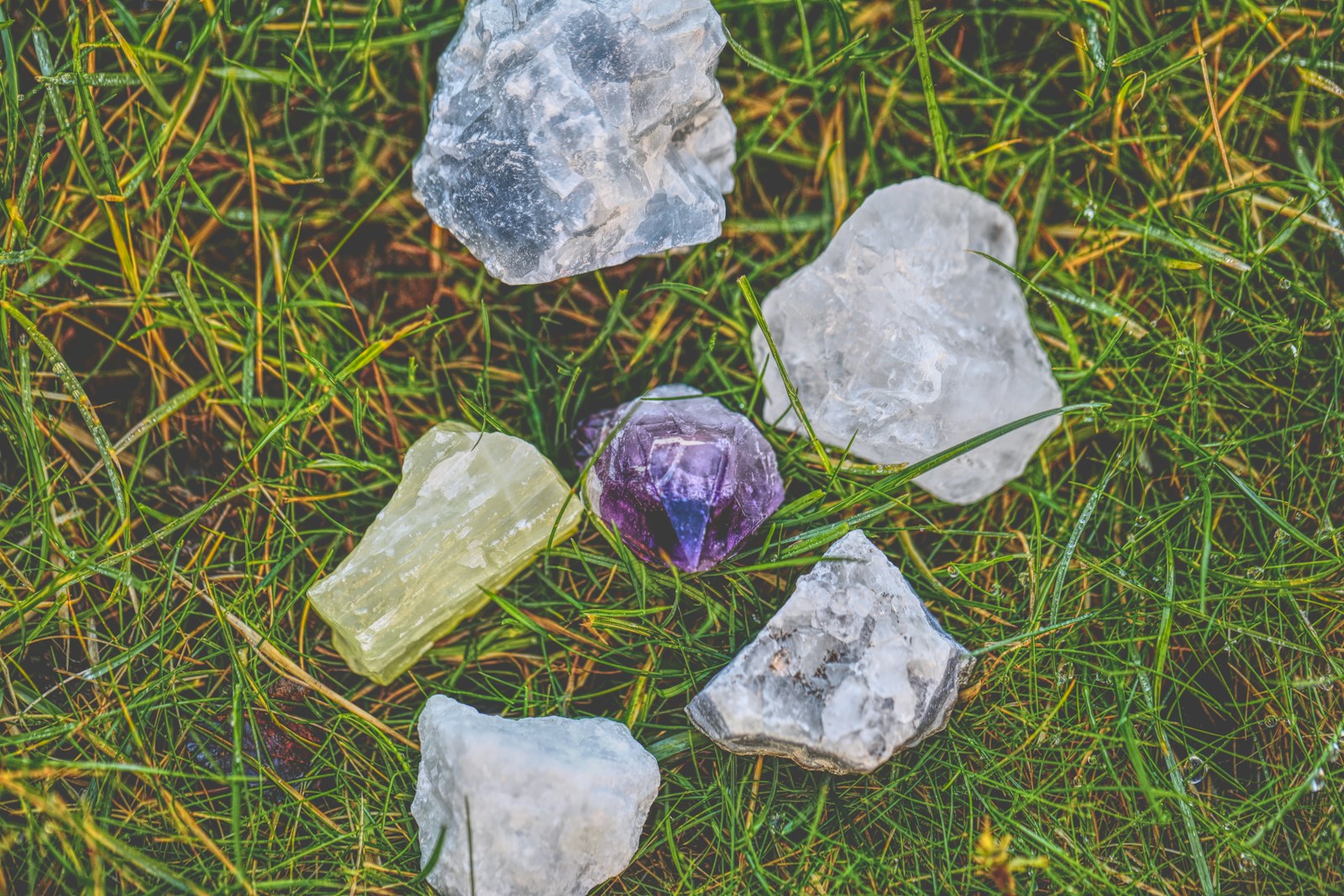 a group of rocks sitting on top of a lush green field